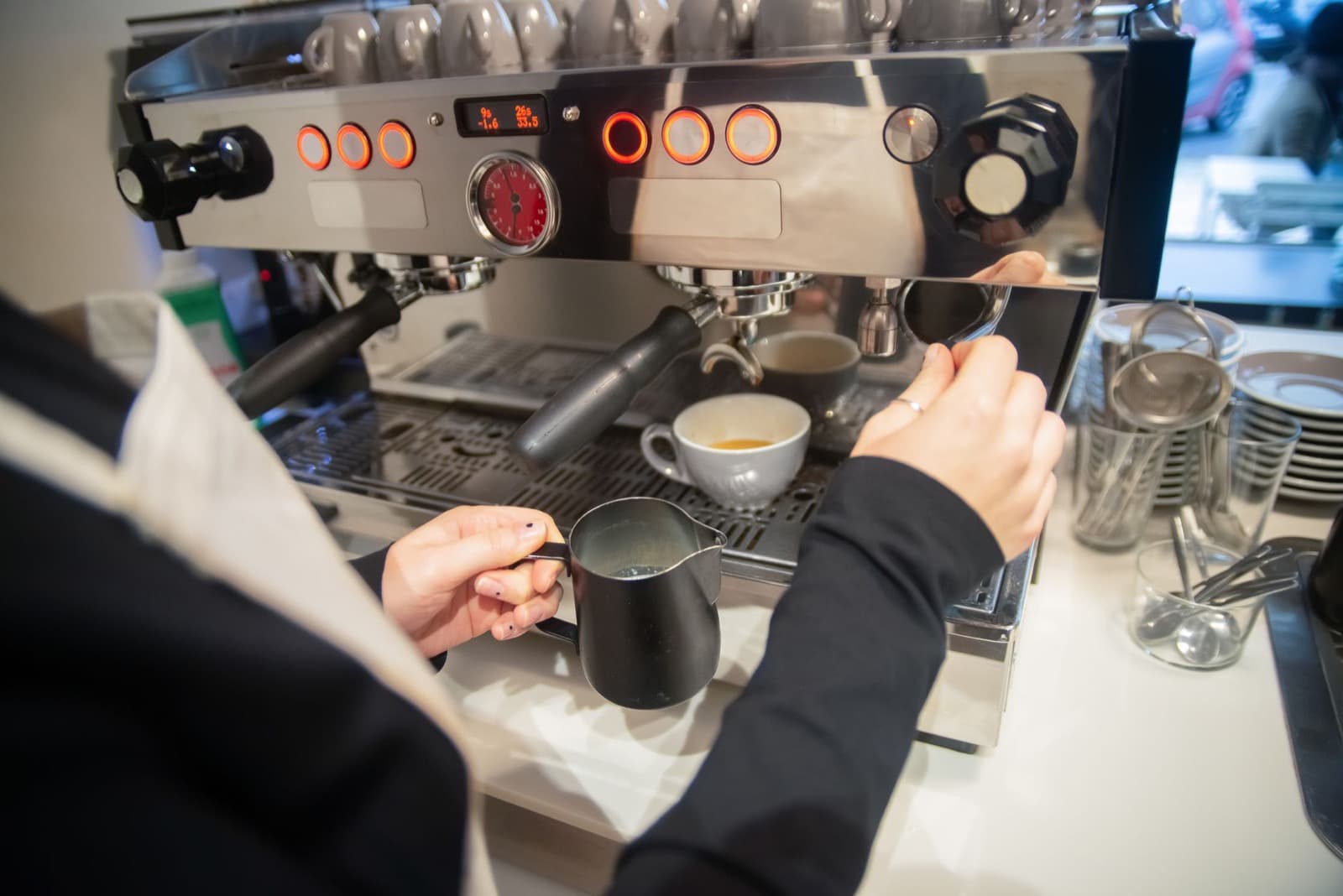 Steam wand steaming milk at an espresso machine.