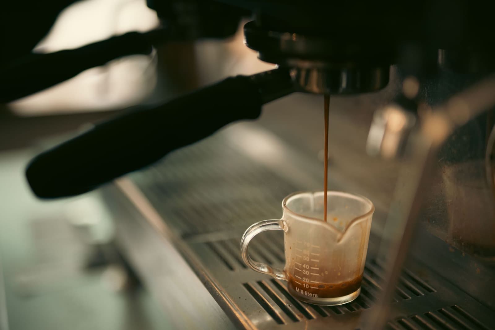 Espresso pouring from a portafilter into a cup.